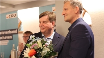 Der Landtagsabgeordnete und Gastgeber Claus Seebeck (rechts) überreichte dem wiedergewählten Bezirksvorsitzenden Enak Ferlemann einen Strauß Blumen.