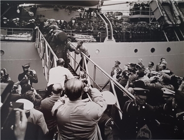 Ein Schwarz-weiß-Foto. Der legendäre Augenblick: Elvis Presley geht in Bremerhaven an Land. An der Gangway klammert Helge Rothenberg für ein Autogramm – er bekam es nicht.