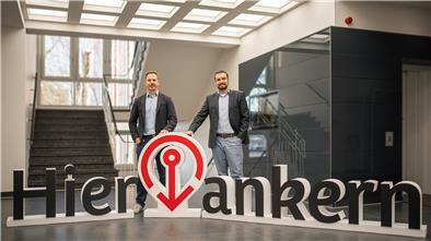 Zwei Männer stehen hinter großen Buchstabenaufstellern.