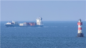 Ein Frachter fährt am Leuchtturm Roter Sand vorbei.