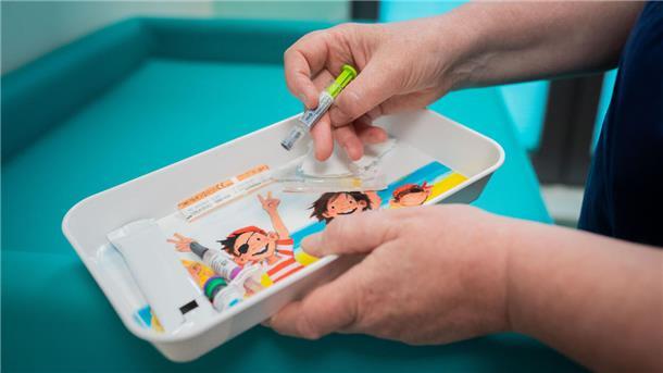 Medizin für Kinder liegt in einer Schale.