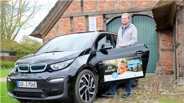 Der Nachhaltigkeitsmanager der Gemeinde Schiffdorf, Birger Auffarth, vor dem elektrischen BMW i3  der Gemeinde. 