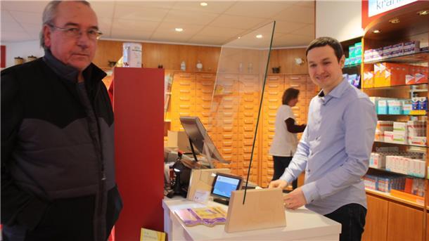 Der neue Apotheken-Besitzer Mykola Sharavara (rechts) bedient in der neu gestalteten Kranich-Apotheke den Kunden Ju¨rgen Hofmann.