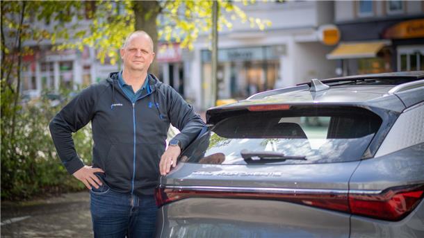 Henning Haag am Heck seines Neuwagens, ein Modell der chinesischen Marke BYD.