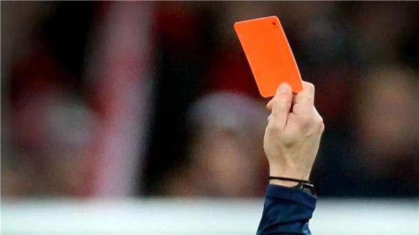 Ein Fußballschiedsrichter zeigt die Rote Karte.
