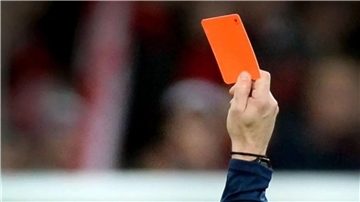 Ein Fußballschiedsrichter zeigt die Rote Karte.