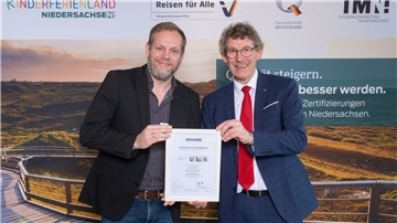 Der Niedersächsische Staatssekretär Frank Doods (rechts) und Eike Hessenius, Einrichtungsleiter des Awo Sano Ferienzentrums Burhave, bei der Übergabe des Zertifikats. 