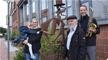 Menschen an Skulptur von einem Saxofonisten