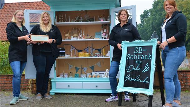 Vier Frauen stehen vor einem alten Bauernschrank.