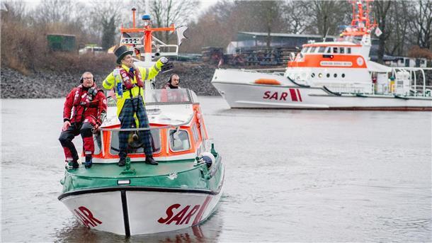 Hunderte Schaulustige trotzen Regen bei Bremer Eiswette Der Schneider überquert mit einem Beiboot der Seenotretter die Weser.