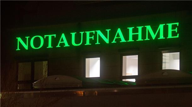 Der Schriftzug „Notaufnahme“ hängt in leuchtendem Grün an einem Krankenhaus.