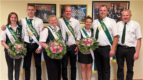 Sieben Personen stehen in Schützenkleidung nebeneinander und lächeln in die Kamera. Es sind die neuen Majestäten des Schützenvereins Ankelohe, darunter das Königspaar, das Jugendkönigspaar und das Vizekönigspaar. Alle tragen Schärpen, teils mit Schützenketten, und halten festlich gebundene Blumensträuße in den Händen.