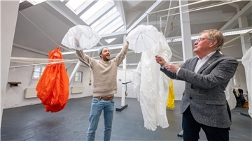 Der Stipendiat Tomas Kleiner und Klaus Becké, der Vorsitzende des Vereins Kunst & Nutzen, haben bereits im Atelier in der Gartenstraße Spaß: Sie werfen die kleinen Fallschirme in die Luft, während die großen noch auf ihren Auftritt warten.