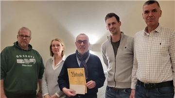Fünf Leute stehen bei der Jahreshauptversammlung der TSG Burhave nebeneinander.