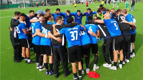 Die Mannschaft des Fußball-Landesligisten TuSpo Surheide steht auf dem Platz und schwört sich im Kreis auf das Spiel ein.