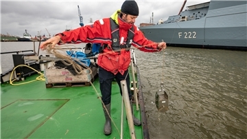 Der Umweltchemiker Nicolai Nowak (47) nimmt von Bord der „Möwe“ aus im Kaiserhafen Wasser- und Schlickproben. Foto Scheschonka