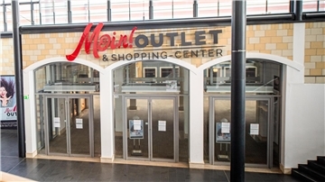 Der verschnörkelte Schriftzug von „Mein! Outlet & Shopping-Center“ spielt mit dem norddeutschen Gruß „Moin!“
