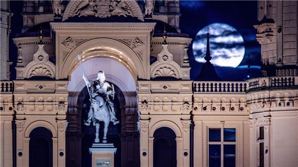Der Vollmond geht über dem Schweriner Schloss auf.