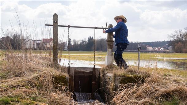 Der Wässerer Jürgen Zwingel öffnet eine Schleuse eines Wässergrabens im Ortsteil Reichelsdorf: Die Traditionelle Wiesenbewässerung ist von der Unesco zum immateriellen Kulturerbe ernannt worden.