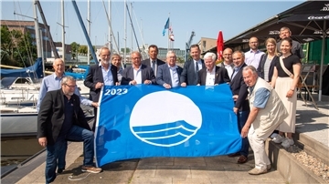 Die Umweltplakette „Blaue Flagge“ ist zu sehen sowie Preisträger.