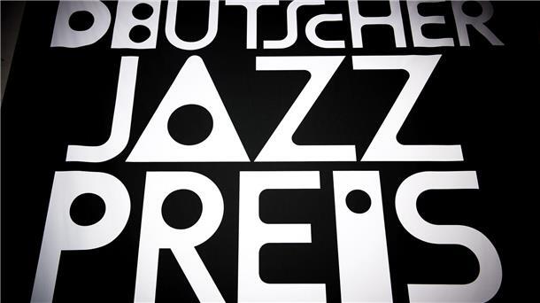 Deutsche Jazzpreise verliehen: Zwei Metropolen liegen vorn „Deutscher Jazzpreis“ steht auf einem Plakat.