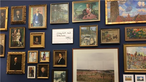 Dicht an dicht hängen die Werke an der Bremer Wand in der Kunsthalle. Christian Holtmann mischt sie mit einem gemalten Preisschild auf. „Komplett mit Rahmen 490 Euro“ ist darauf zu lesen.