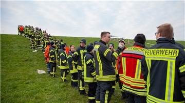 Dicht nebeneinander standen die Einsatzkräfte in Cappel-Neufeld. Ihre Aufgabe: Mehr als zehn Kilogramm schwere Sandsäcke bis zur Deichkrone durchzureichen.