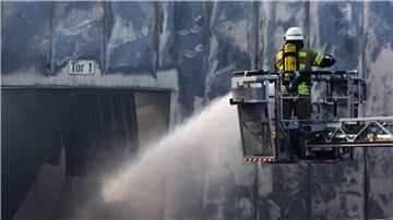Dichte Rauchschwaden steigen am Sonntag aus den brennenden Hallen auf.