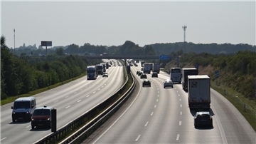 Eine breite Straße und Autos, die in beide Richtungen fahren.