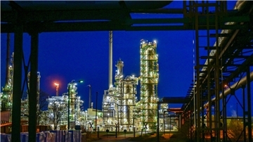 Die Anlagen der Erdölraffinerie auf dem Industriegelände der PCK-Raffinerie GmbH sind abends beleuchtet.
