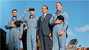 Die Apollo-13-Crew, Fred W. Haise (von links), Jim Lovell und John Swigert, salutiert während der Feierlichkeiten vor der US-Flagge, nachdem ihnen US-Präsident Richard M. Nixon die Freiheitsmedaille überreicht hat.