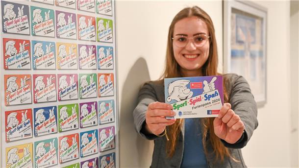 Eine Frau hält ein Prospekt in die Kamera.