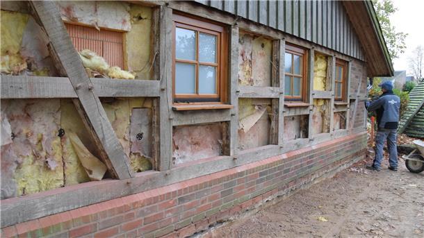 Die Arbeiten für den Anbau an das Ostereistedter Fachwerkhaus haben am Montag begonnen. Ein Handwerker entfernt Steine aus dem hölzernen Ständerwerk.