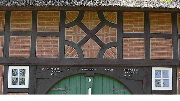 Torbogen eines Fachwerkshauses mit der Jahreszahl 1774, darüber ein Fachwerk-Krückenkreuz