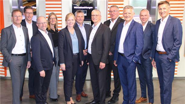 Eine Gruppen von Männern und Frauen in Anzügen, Vorstände und Aufsichtsratsvorsitzende der  der Raiffeisen-Volksbank Varel-Nordenham, der Raiffeisenbank Butjadingen-Abbehausen und der Volksbank Jever.