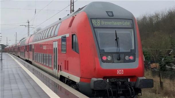 Symbolbild Bahnstrecke Bremerhaven–Bremen gesperrt: Eine Bahn hält am Bahnhof, an dem Menschen warten. 