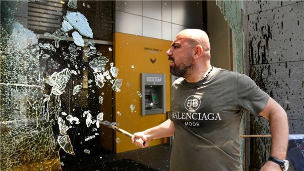 „Die Banken im Libanon stehlen unser Geld!“: Ein Demonstrant zerschlägt Fensterscheiben der Byblos Bank.
