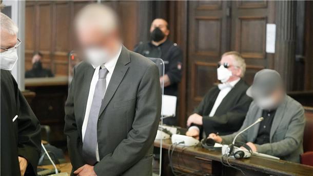 Kind stirbt nach Routine-Operation: Urteil erneut verschoben Die beiden angeklagten Ärzte (hinten r und vorne 2.v.l) warten im Sitzungssaal des Landgerichts.