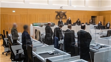 Die beiden Angeklagten (l) stehen bei Prozessbeginn in einem Gerichtssaal des Oberlandesgerichts Stuttgart.