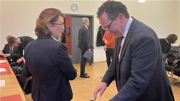 Zwei Personen nebeneinander im Gerichtssaal.
