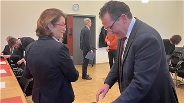 Zwei Personen nebeneinander im Gerichtssaal.