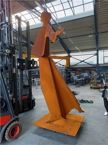 Eine Stahlskulptur mit dem Titel  „Christ Dansant“ steht in einer Lagerhalle