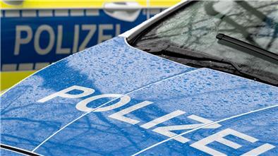 Der Schriftzug „Polizei“ ist auf der Kühlerhaube eines Autos zu lesen 