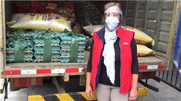 Die Bremerhavenerin Meike Tiedemann steht vor einemLaster, mit dem in Lima Lebensmittel ausgefahren werden.