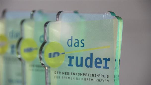 Ein gläserner Pokal mit der Aufschrift "das ruder" steht auf einem Tisch. Die Bremische Landesmedienanstalt verleiht in diesem Jahr erneut den Medienkompetenzpreis „das ruder“.