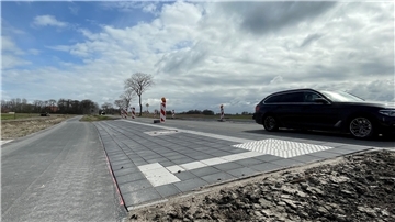 Eine Bushaltestelle am Straßenrand. Die Steigung ist deutlich erkennbar.