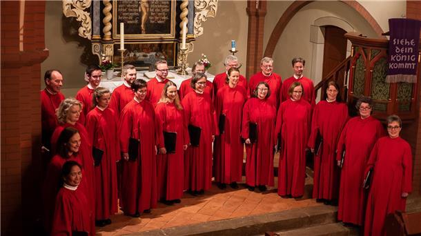 Chorkonzert in der St.-Dionysius-Kirche am 2. November Menschen in roten Chorgewändern stehen vor einem Altar.