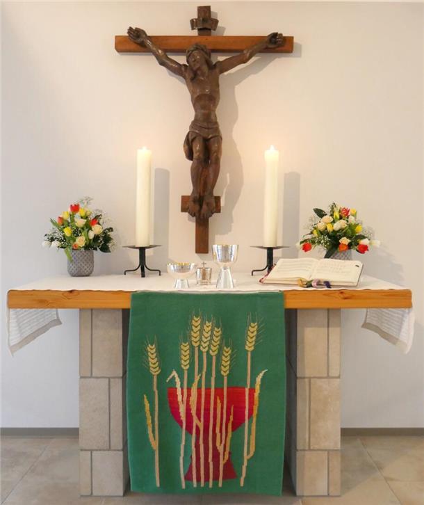 Auf einem Altar stehen zwei brennende Kerzen.