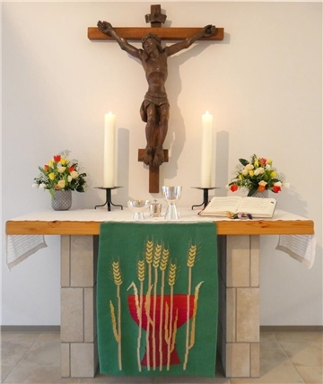 Auf einem Altar stehen zwei brennende Kerzen.