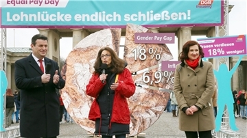 Die DGB-Vorsitzende Yasmin Fahimi (M) gibt am Vortag des Internationalen Frauentages ein Statement zum Equal Pay Day vor dem Brandenburger Tor ab. Neben ihr: Bundesarbeitsminister Hubertus Heil.